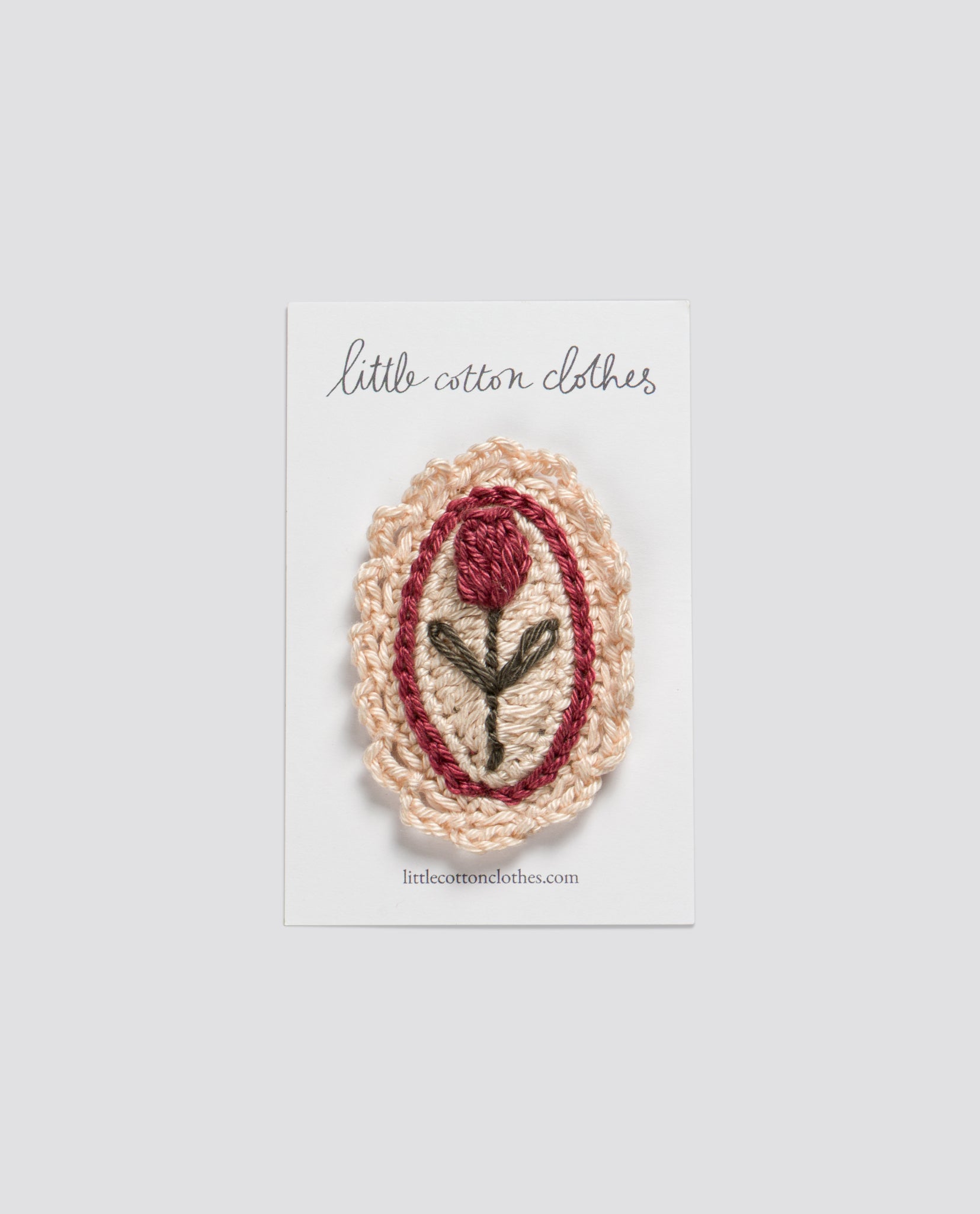 Crocheted tulip hair clip in pink and cream tones on a card, showcasing a natural, vintage-inspired accessory for girls from an ethical children's clothing brand.