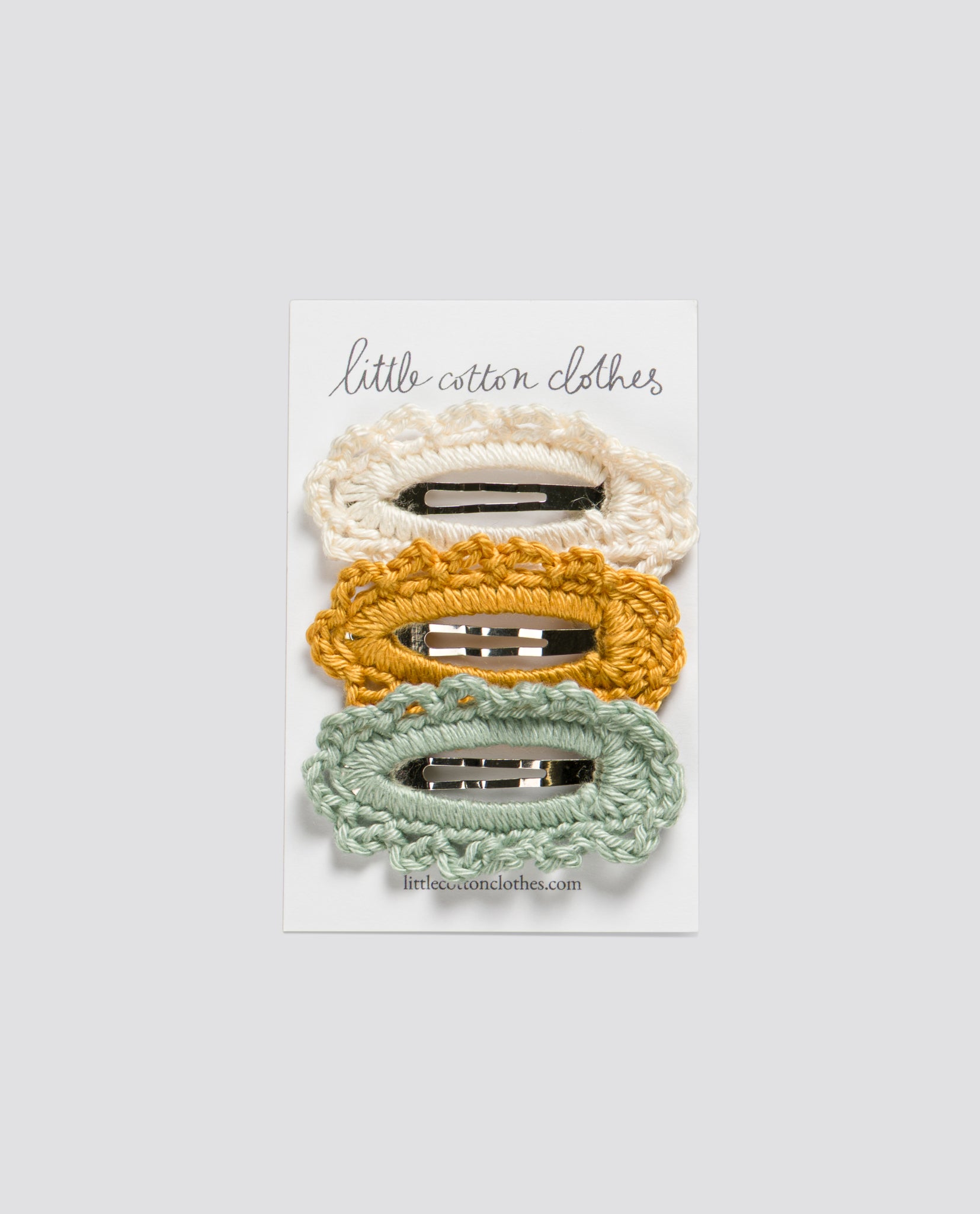 Set of three handmade crochet hair clips in cream, yellow, and aqua, made with natural materials for a vintage-inspired, sustainable children's accessory.
