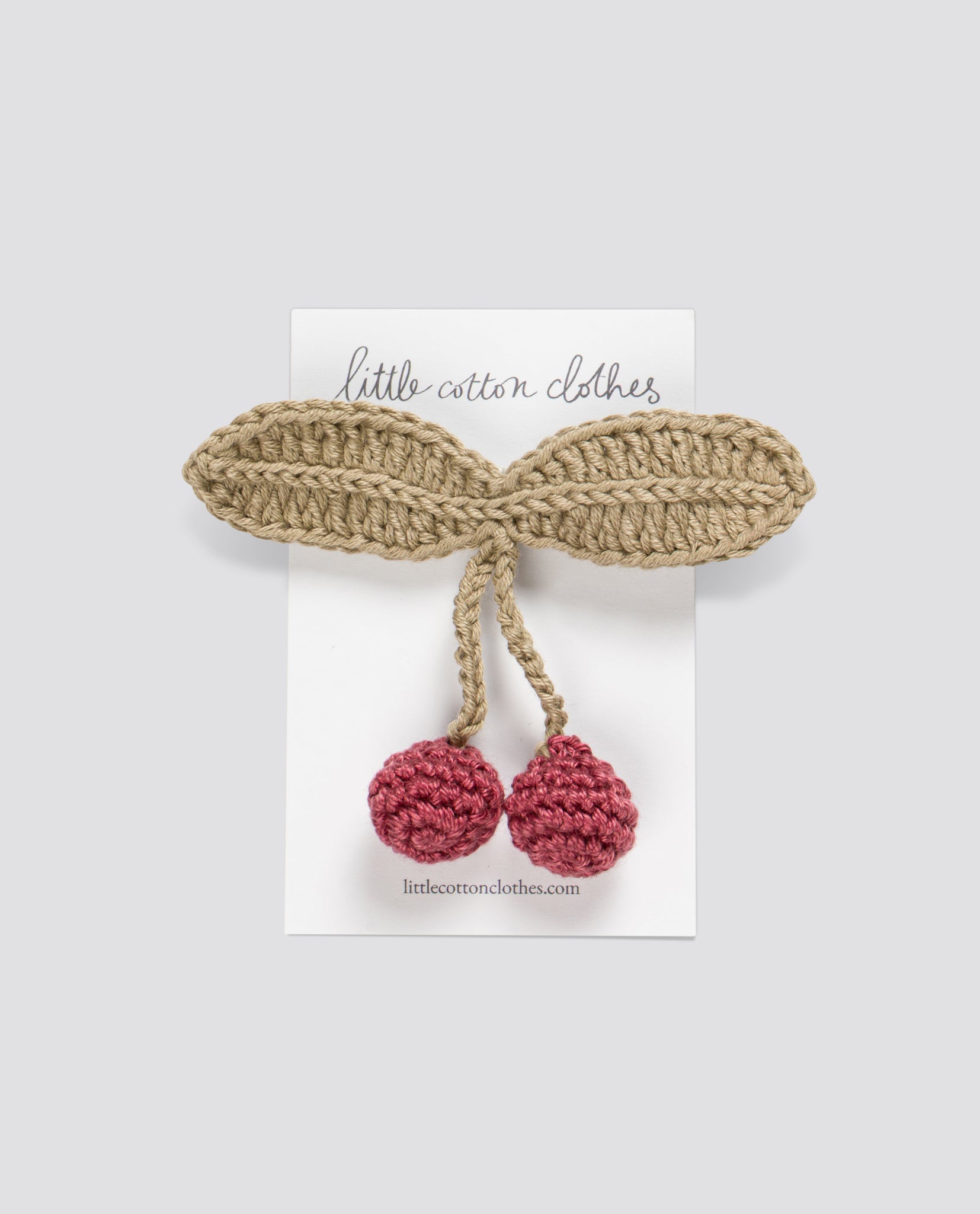 Handcrafted crochet hair clip featuring organic cotton cherries with vintage-style leaves, designed for children in an ethical and sustainable way.