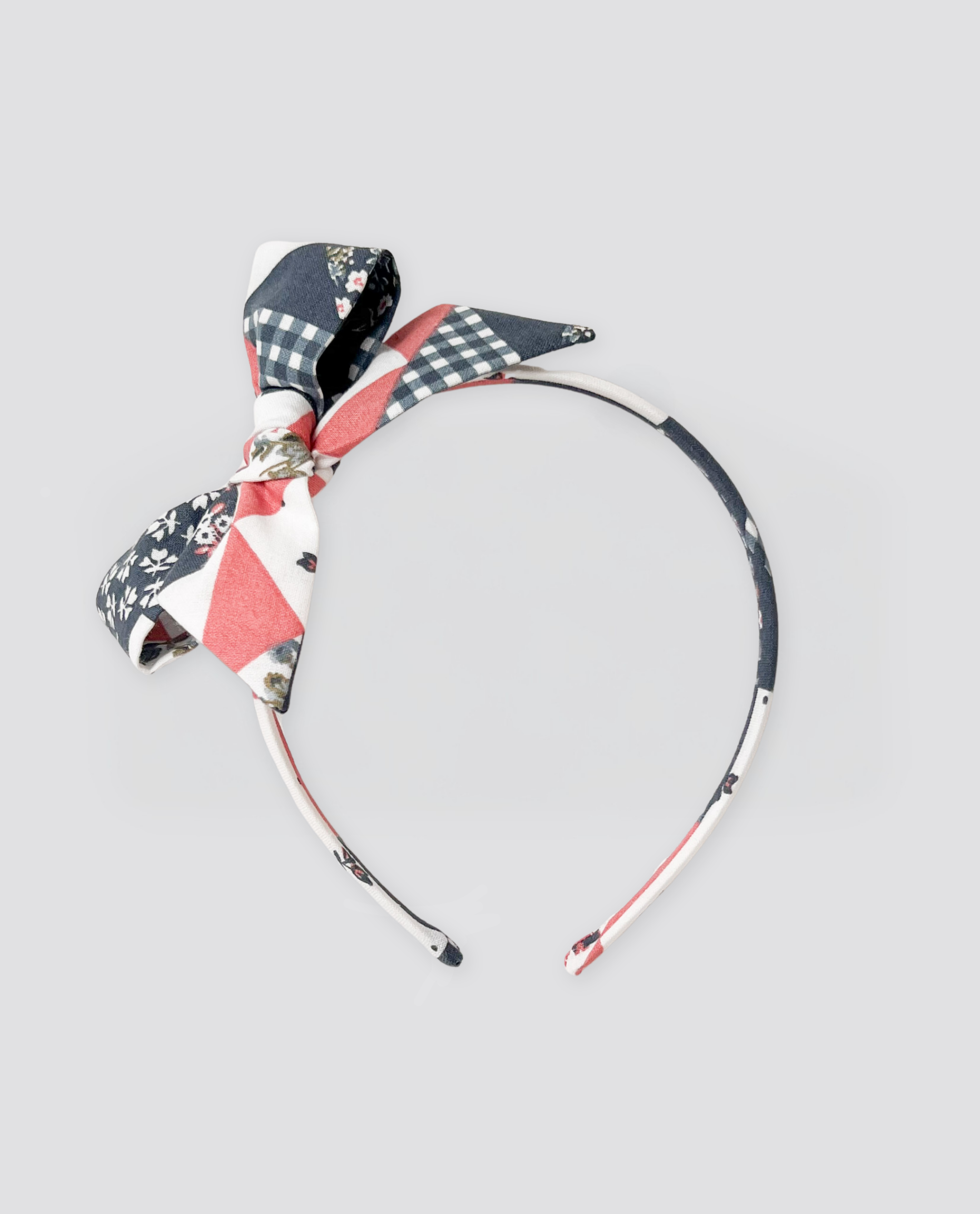 Girls' vintage-style patchwork floral Alice band made from organic cotton with a charming bow, designed for sustainable, natural children's clothing.