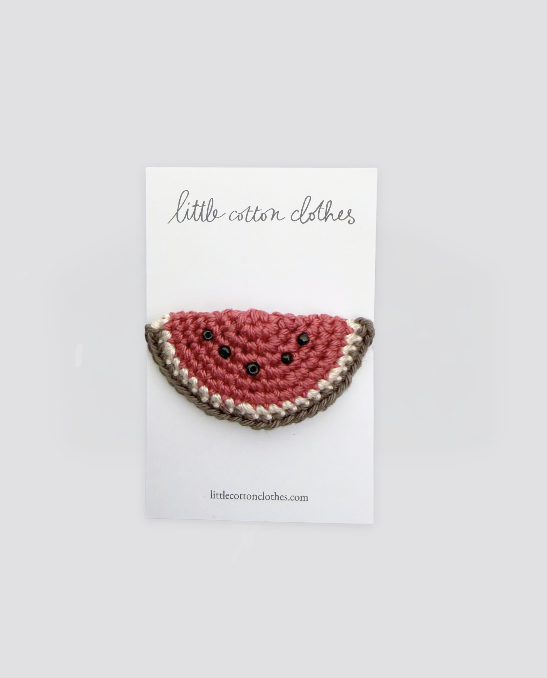 Handcrafted crochet watermelon hair clip with natural cotton yarn, designed with vintage style for children, showcasing ethical and sustainable craftsmanship.