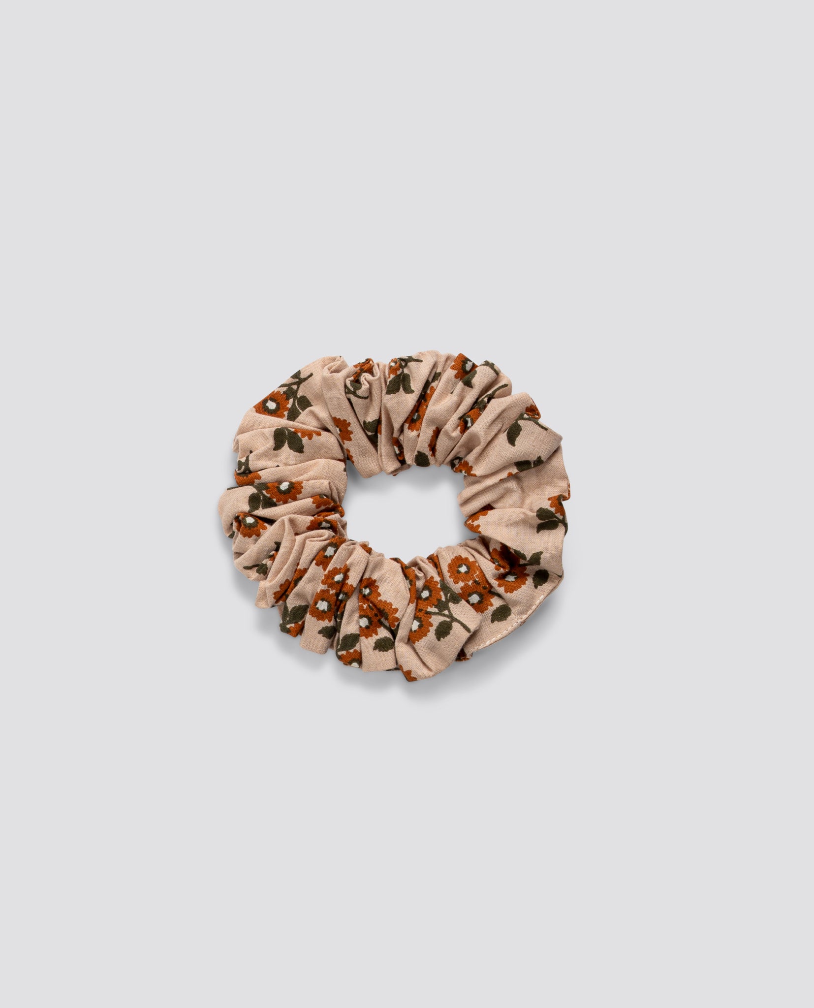 Soft cotton scrunchie in vintage-inspired marigold floral print, ethically made with natural materials for gentle, sustainable children's wear accessories.