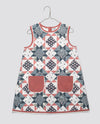 Sleeveless girls dress in a patchwork floral pattern with a cotton blend fabric, featuring vintage-inspired design and two front pockets in soft rose color, ethically made.