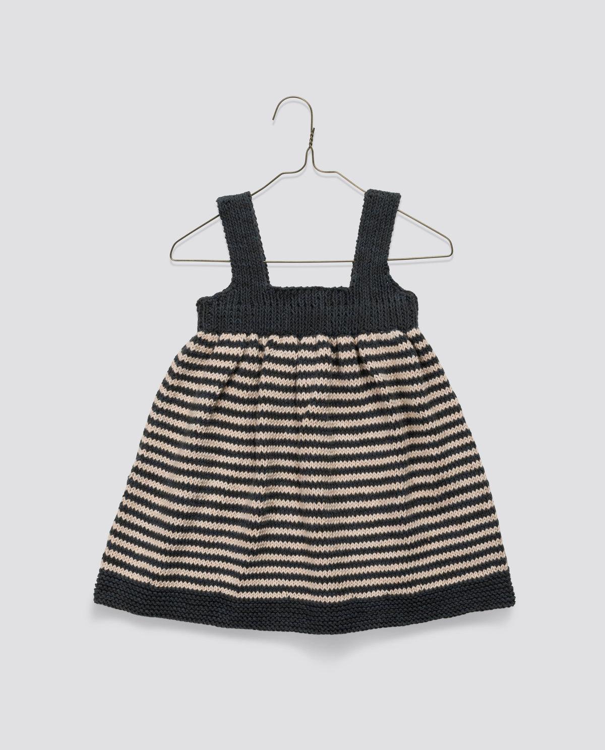 Pretty hand-knitted pinafore, crafted with care reflecting ethical and sustainable values for children's clothes.