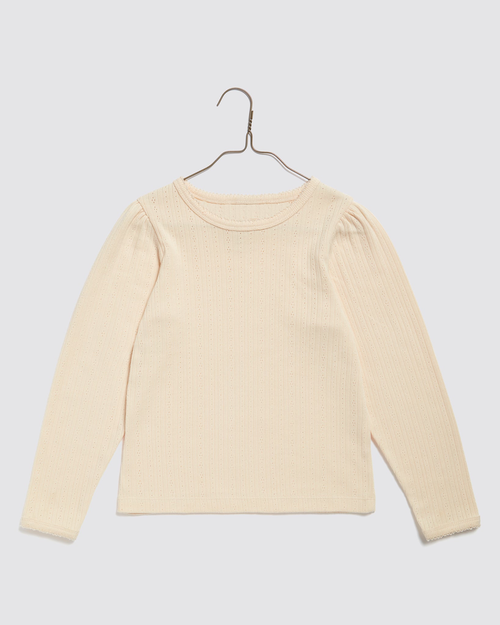 Cream-colored organic cotton long sleeve T-shirt for kids with a delicate pointelle pattern, featuring a soft stretchable fabric and vintage-inspired design.
