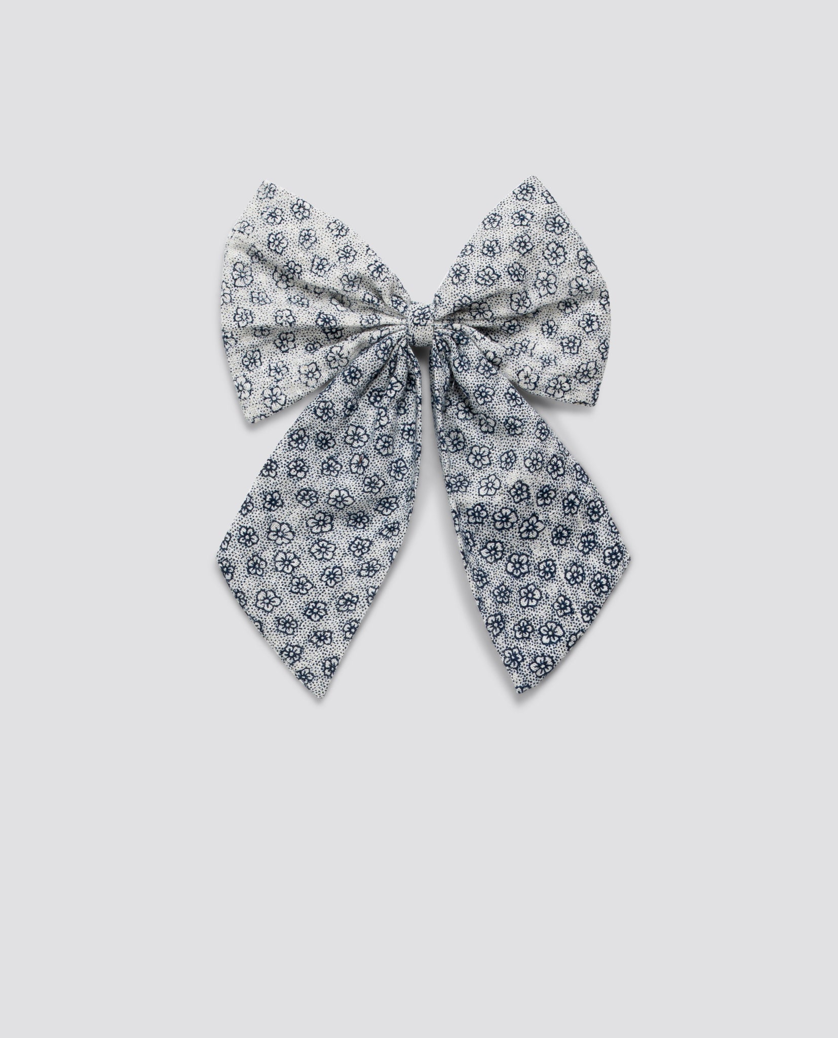 Delicate vintage-style floral fabric bow with elastic, crafted from organic cotton for a natural, sustainable accessory perfect for children's clothing.