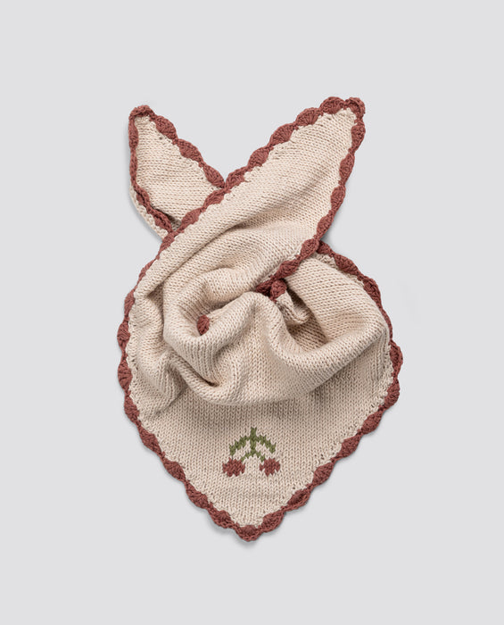 Soft cream cotton scarf with hand-knitted cherry detail and vintage-inspired rust-colored scalloped edges, crafted sustainably for children’s organic clothing.
