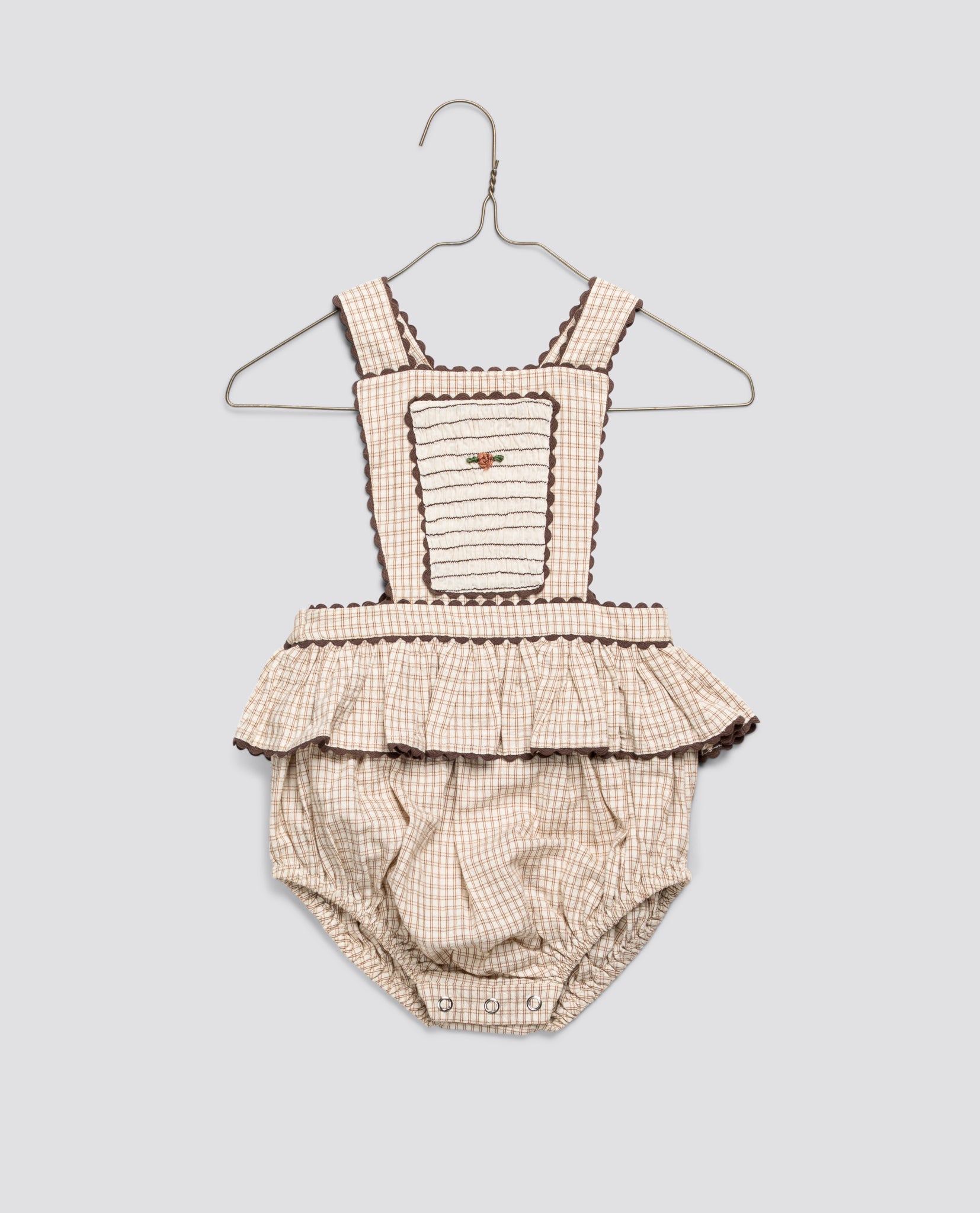 Vintage style baby romper in soft straw check cotton with delicate embroidery and ruffle detail, made from organic, sustainable materials for ethical children's clothing.