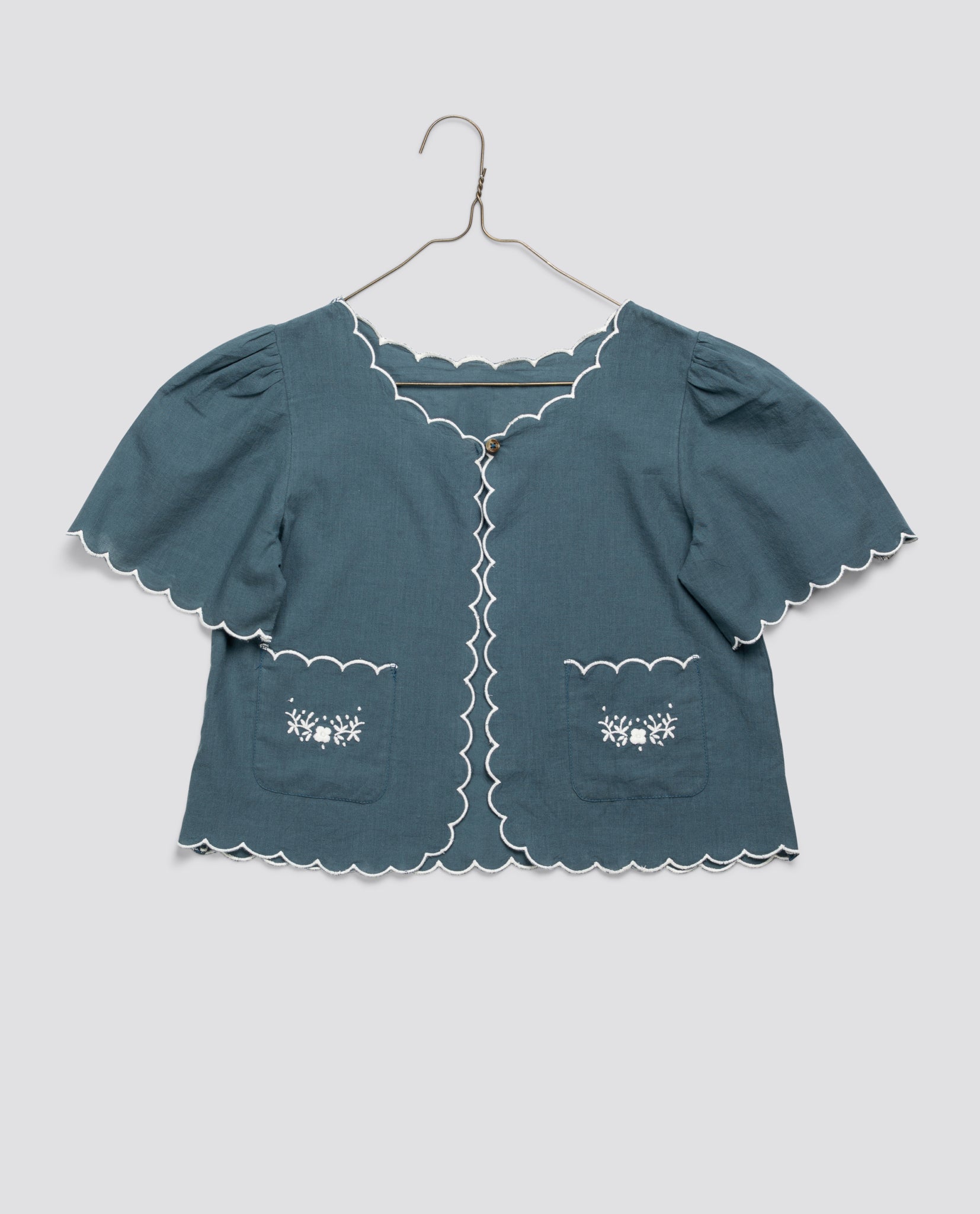 Blue organic cotton girls jacket with scalloped edges and embroidered pockets, showcasing a vintage-inspired, sustainably made children's clothing style.