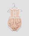Vintage style baby romper in soft powder pink organic cotton with delicate lace trim, designed for comfort and sustainability in children's clothing.