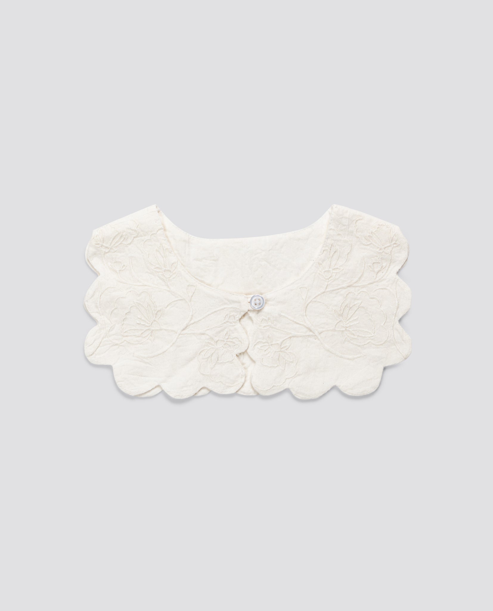 Soft organic cotton scalloped collar with delicate floral embroidery, designed for vintage-style children's clothing, ethically made for a natural, timeless look.