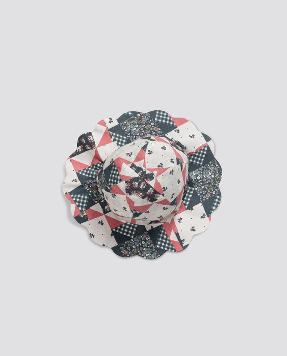 Scalloped patchwork floral hat for children made from organic cotton, featuring vintage-inspired patterns in soft natural colors, perfect for sustainable kids clothing.