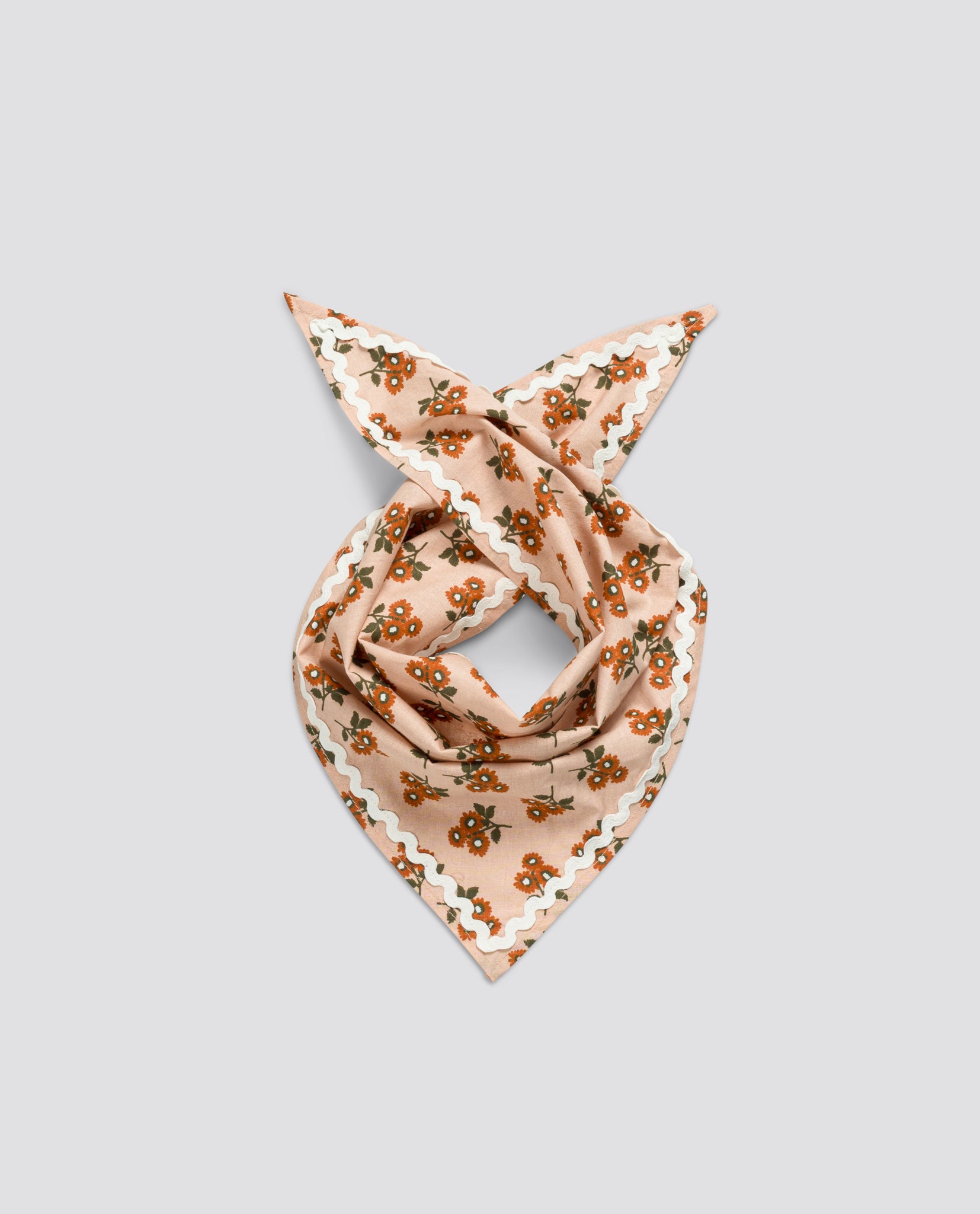 Light brown organic cotton scarf with marigold floral pattern and white scalloped edges, designed with a vintage style for children’s natural and sustainable clothing.