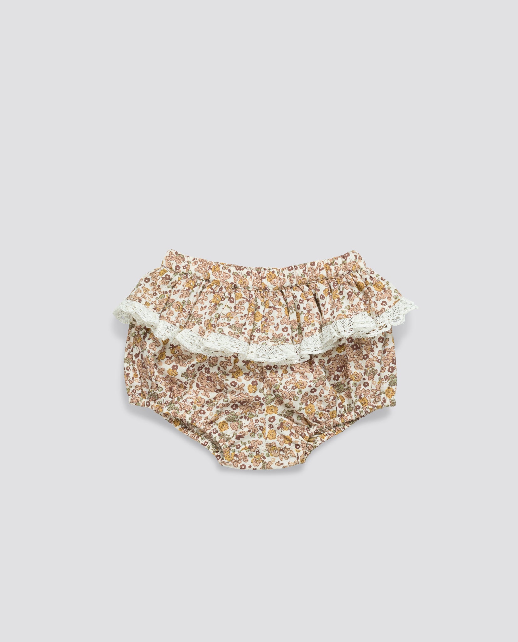 Floral patterned bloomers made from organic cotton featuring a vintage-inspired frill with lace trim, designed for babies and toddlers in a sustainable, ethical style.