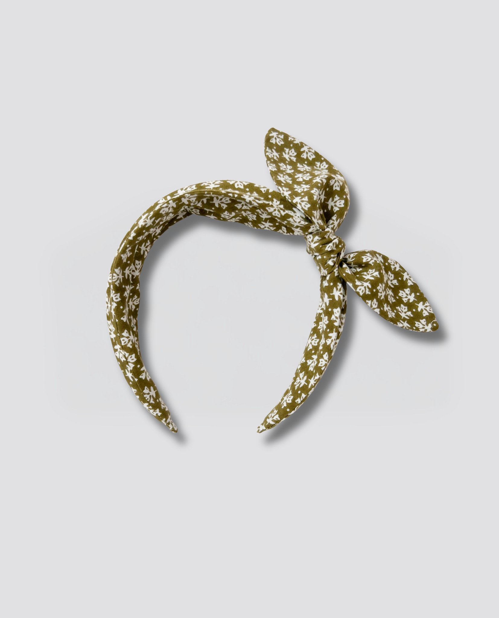 Olive green wide hairband with small white floral print, featuring a vintage-inspired knotted bow, made from natural materials for sustainable children’s clothing.