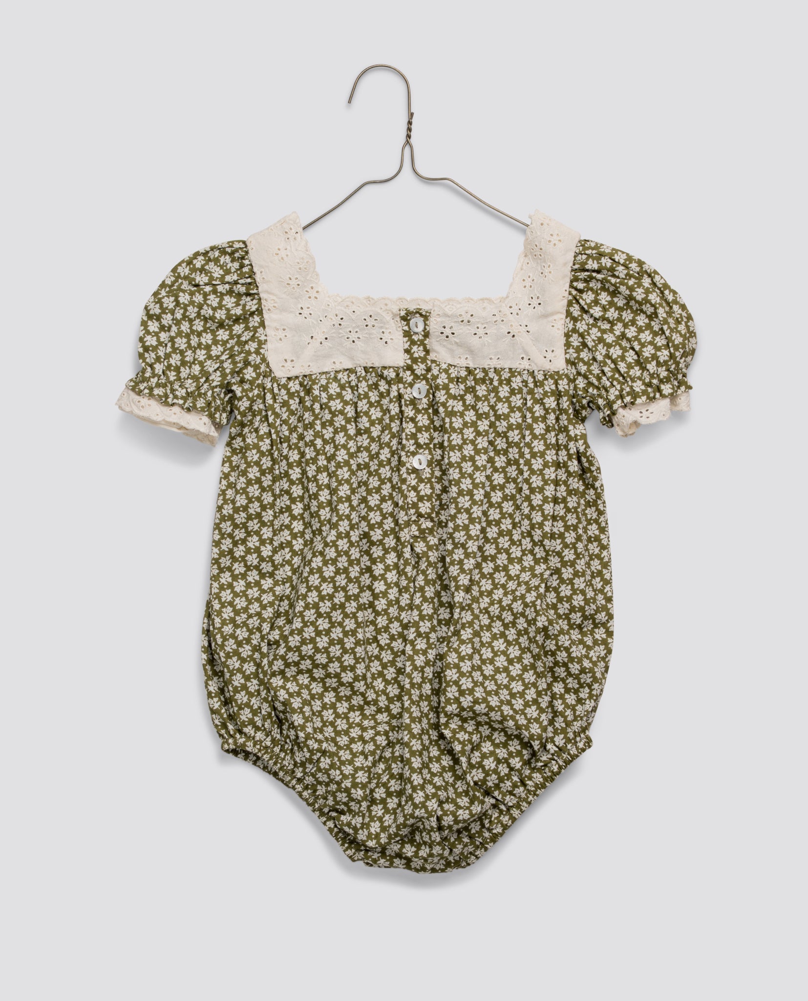 Vintage style baby romper with green floral print and delicate cream lace trim, made from organic cotton for safe, natural, and sustainable children's clothing.