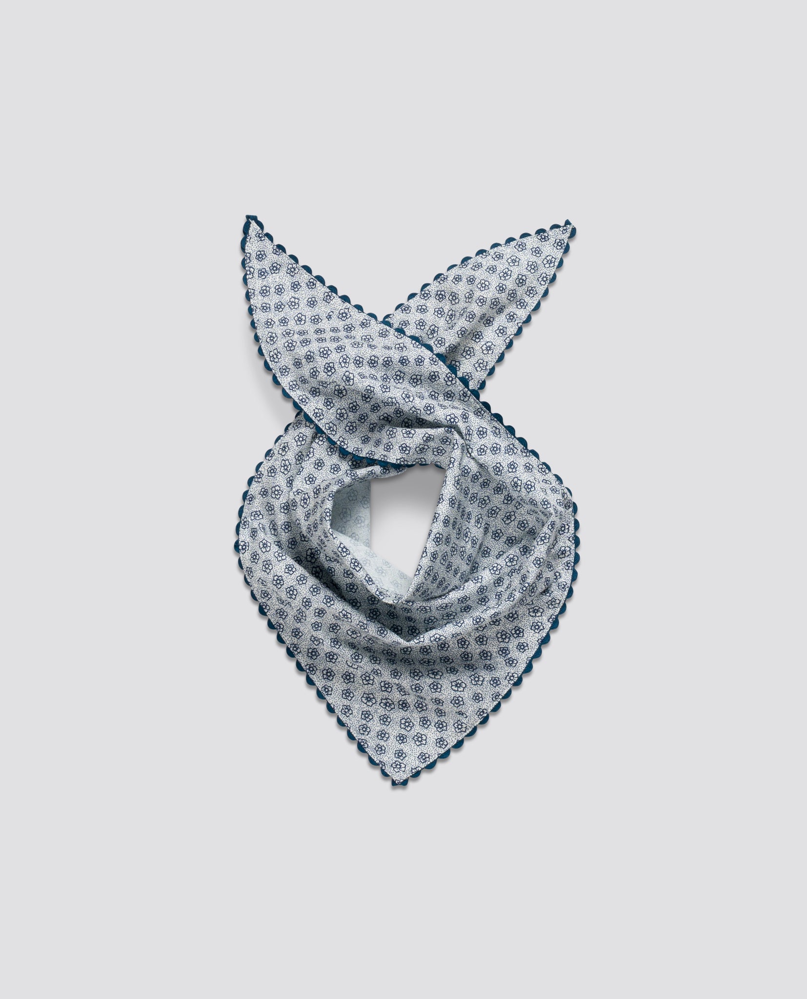 Lightweight vintage-style scarf for children featuring a delicate floral pattern in soft blue on organic cotton with scalloped edges for an ethical, natural look.
