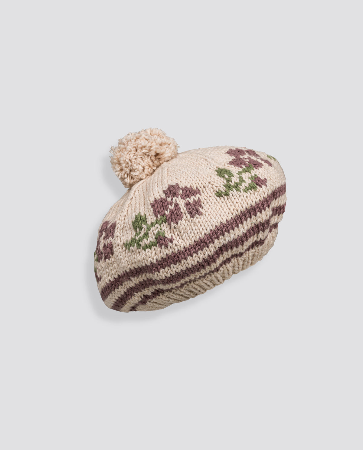 Hand-knitted beret for children featuring a vintage-inspired winter rose pattern and soft pompom, crafted with care from sustainable materials for ethical children's accessories.