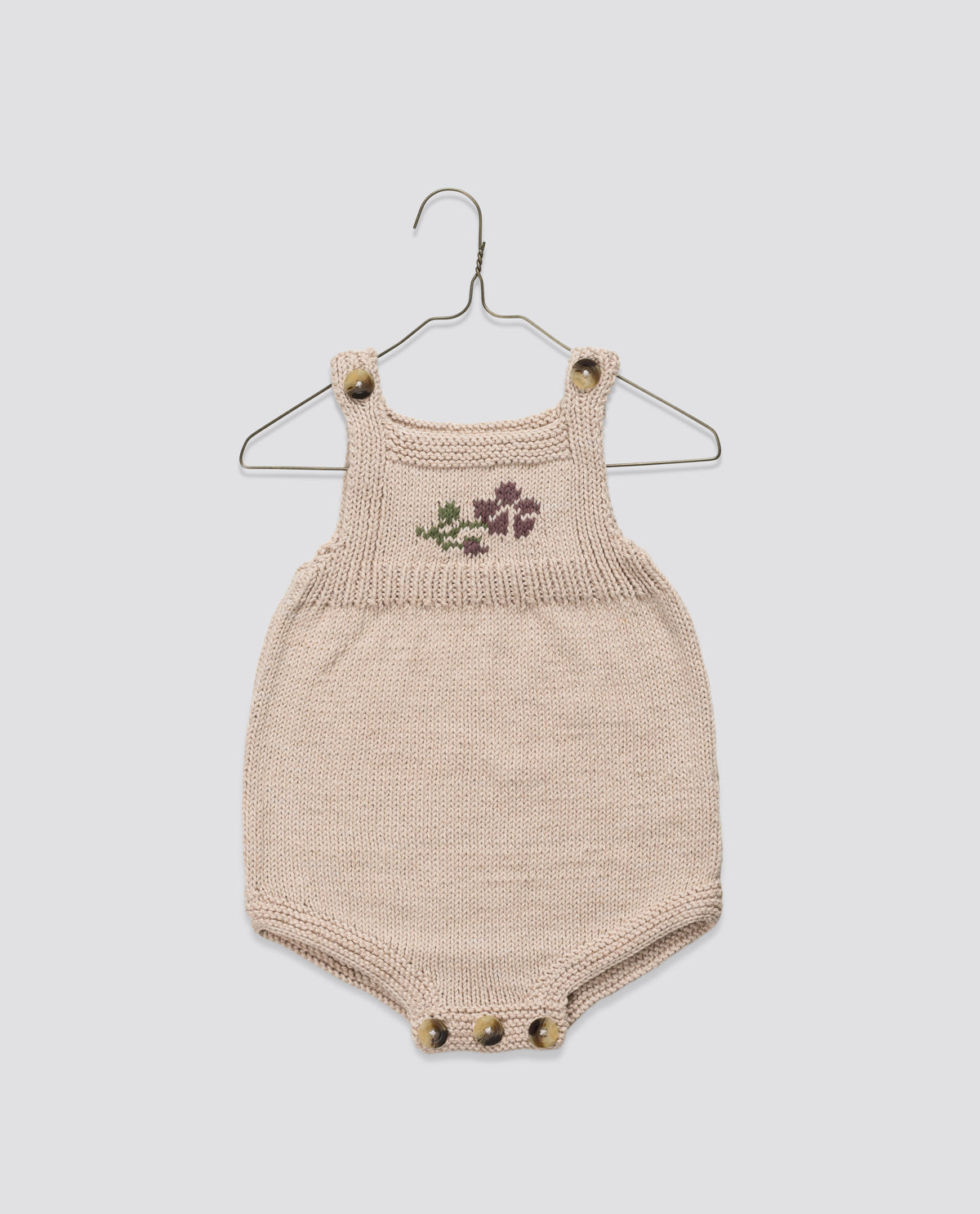 Hand knitted woolen pinafore with vintage inspired rose design, ethically and sustainably made to last.