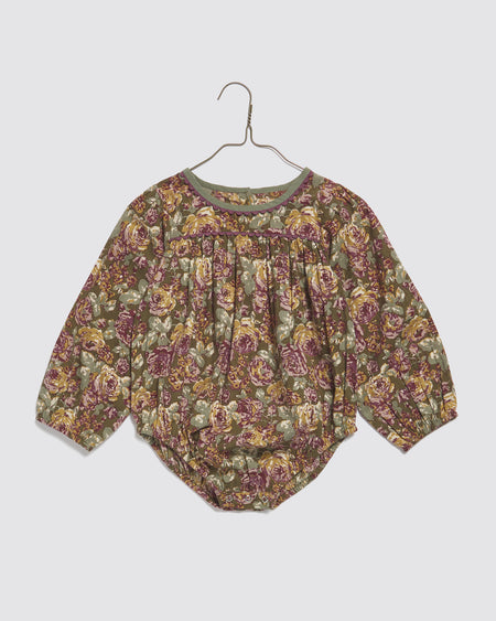 Long sleeved baby romper made from 100% organic cotton in a large scale vintage inspired floral print. Contrasting ric-rac trim and cotton binding to the neck. Sustainable and ethical children's clothing.