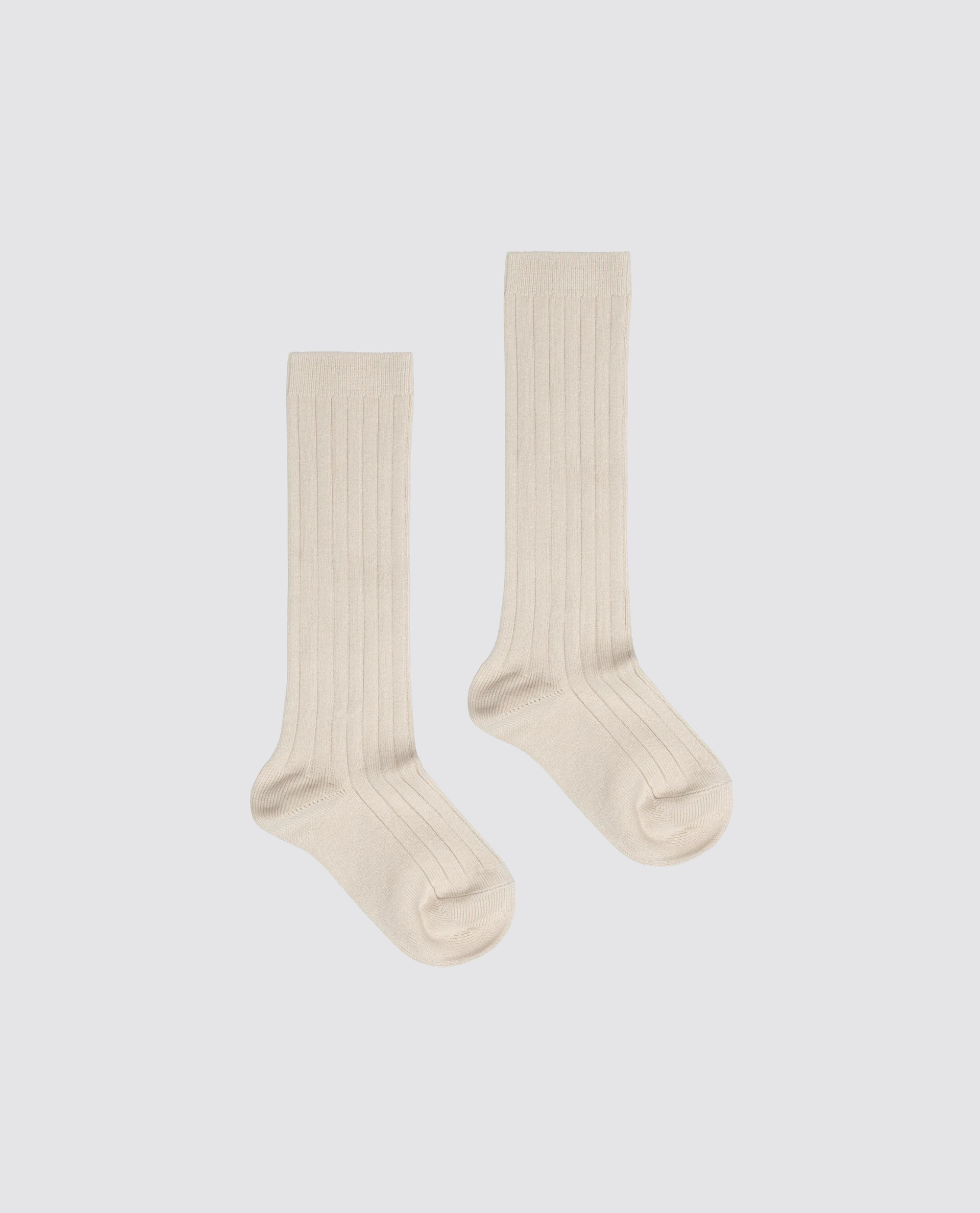 Pair of beige ribbed knee-high socks made from a soft cotton blend, designed for kids with a vintage-inspired, natural, and sustainable style.
