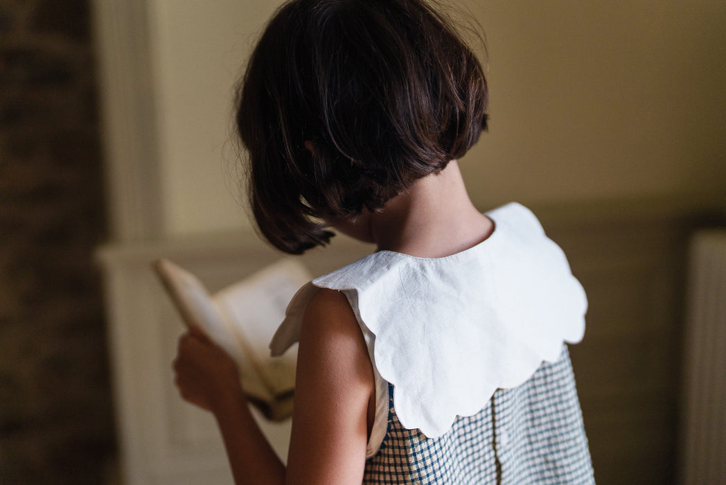 Back view of beautifully made, organic cotton collar with scalloped edge paired with a vintage style, blue, a line girls dress.