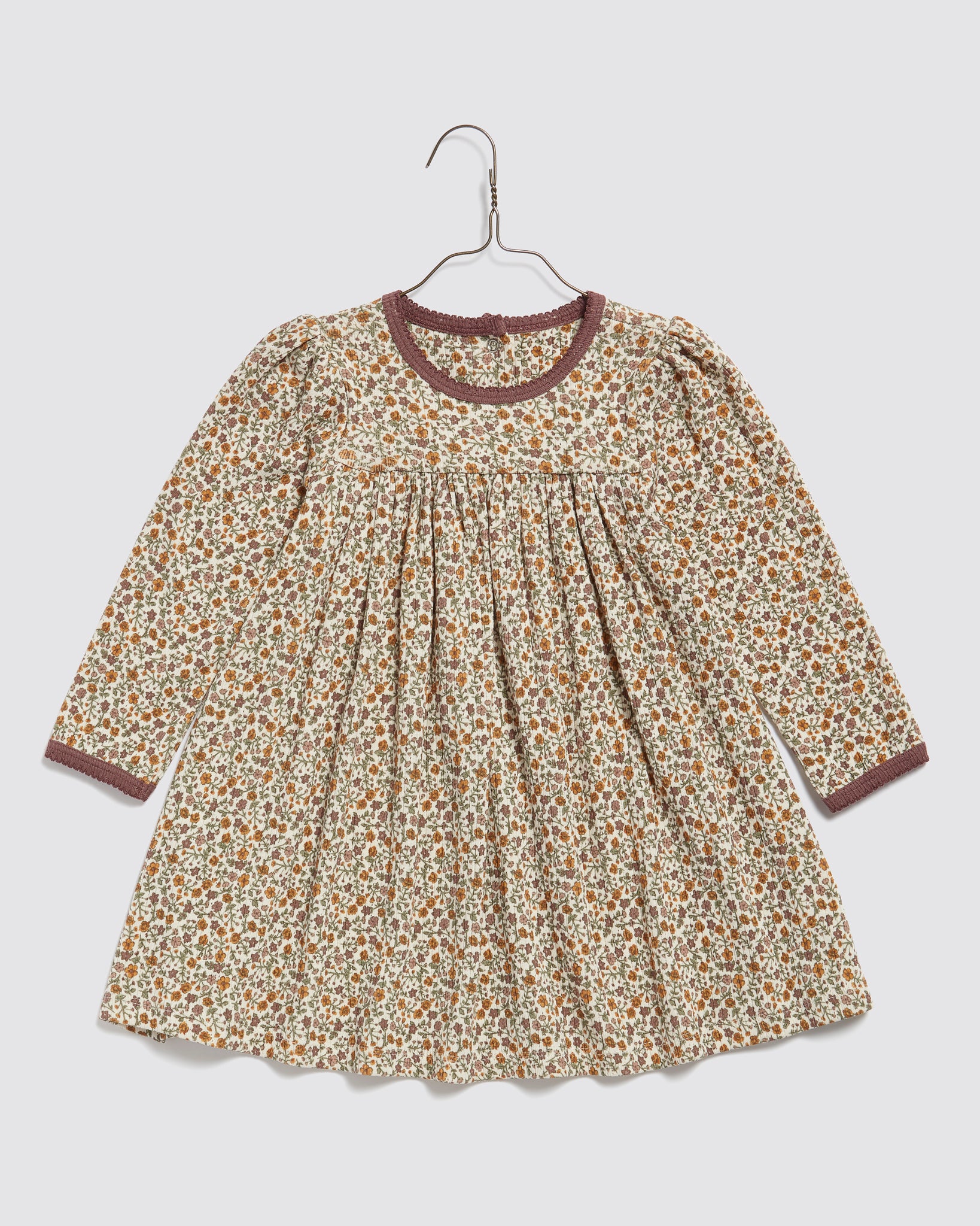 Vintage-style long sleeve girls dress in organic cotton with a multicolor prairie floral pattern and contrast trim, designed for comfort and sustainability.