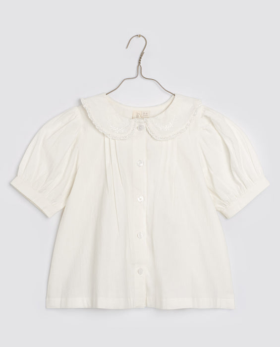 A perfect staple vintage inspired embroidered cotton blouse for girls with pin-tucks, puff sleeves and a gorgeous peter pan collar and crochet cotton trim. Sustainably made in off-white organic cotton with button opening.
