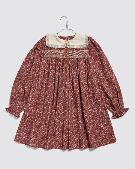 This beautiful girls Christmas party dress,  made in red floral print fabric. It has a sailor collar with gathered lace trim.  and hand-smocked panel to the chest. Sustainably and ethically made in organic cotton fabric.