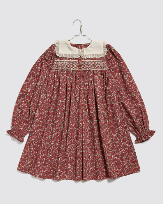 This beautiful girls Christmas party dress,  made in red floral print fabric. It has a sailor collar with gathered lace trim.  and hand-smocked panel to the chest. Sustainably and ethically made in organic cotton fabric.