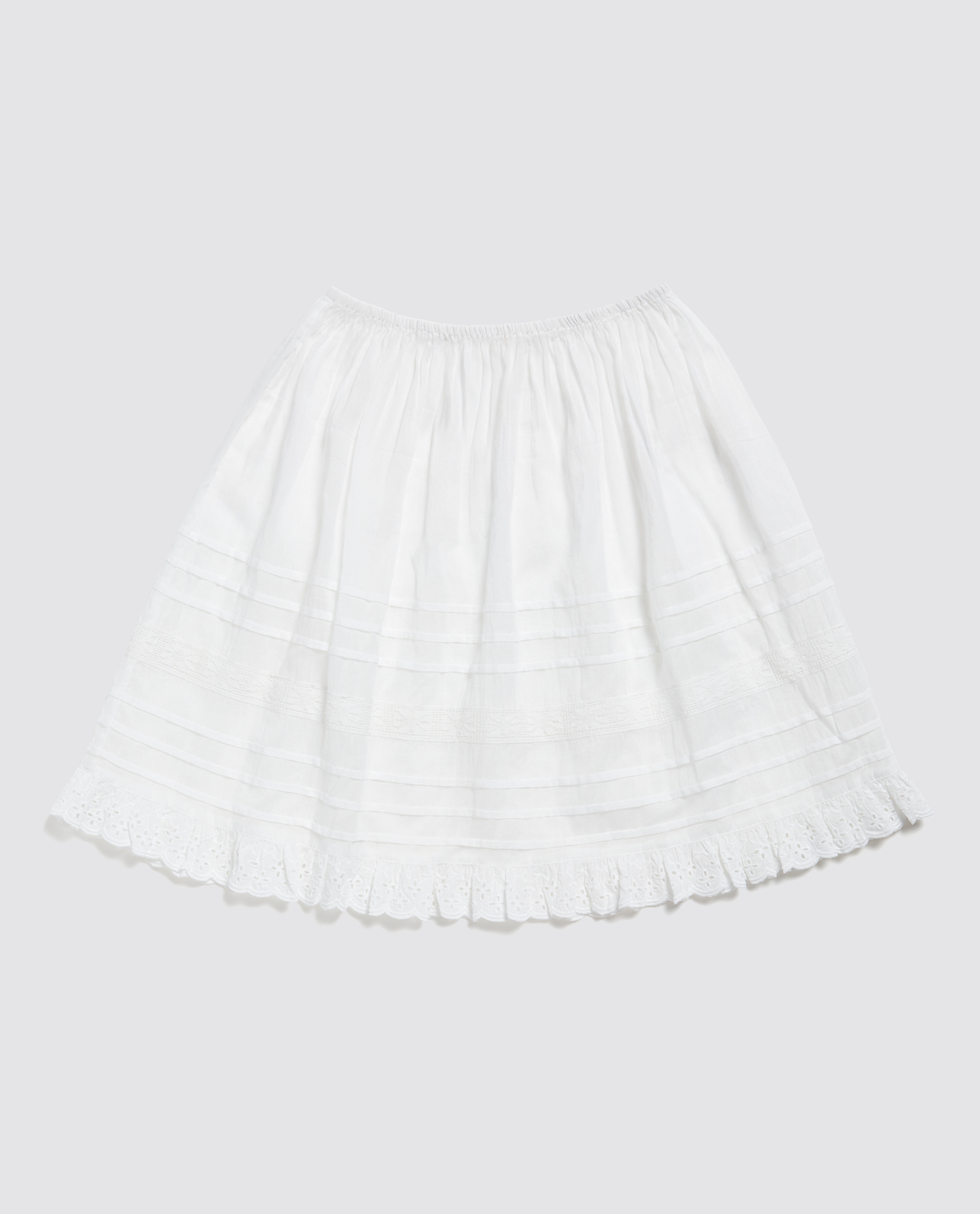 White organic cotton petticoat for kids featuring delicate pintuck details and a vintage-style scalloped hem, crafted with natural, sustainable materials.